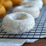 pumpkin donuts with icing sugar on a cooling rack