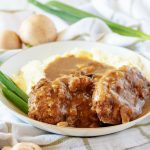 Salisbury steak on a plate with mashed potatoes