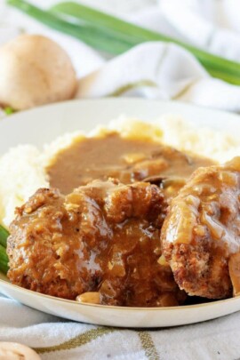 Salisbury steak on a plate with mashed potatoes