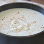 instant pot creamy cauliflower soup in a bowl with seasoning on top