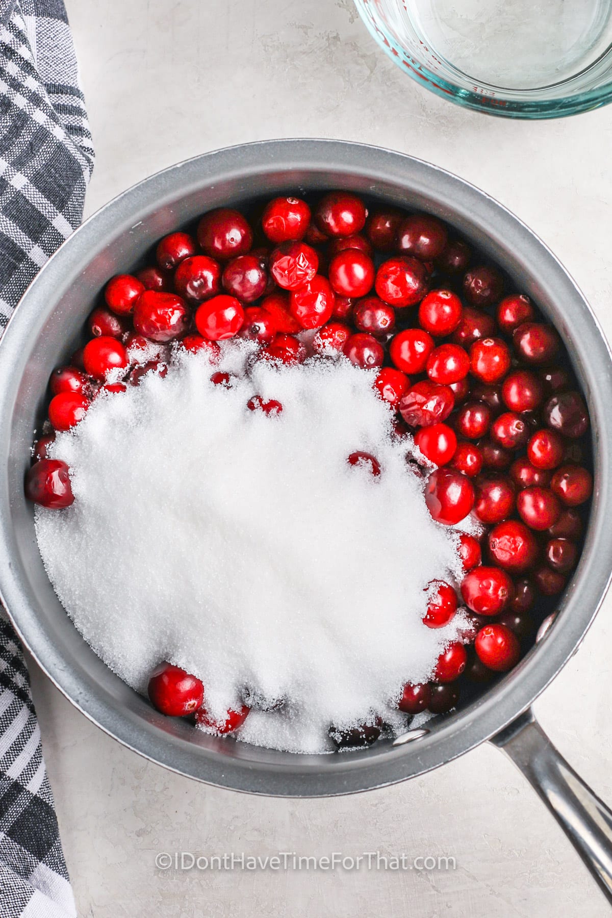 adding sugar to cranberries to make Easy Cranberry Sauce