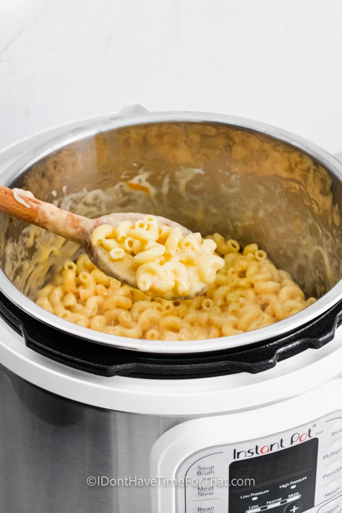 taking a spoonfull of Instant Pot Mac and Cheese out of the pot