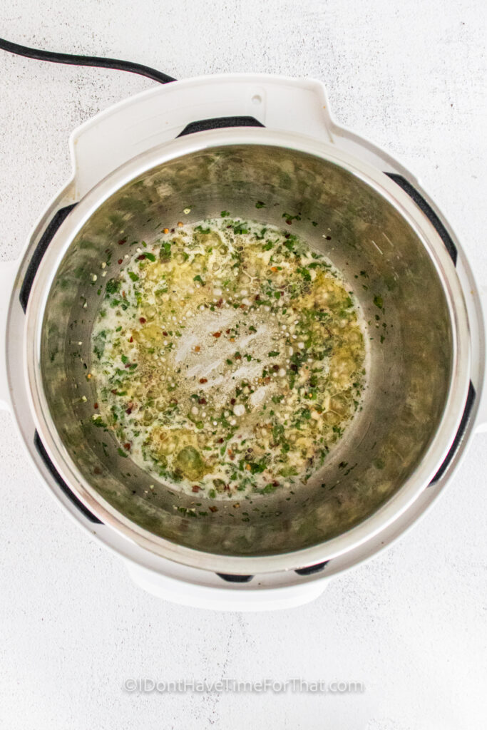 cooking garlic with seasonings to make Garlic Parmesan Chicken Thighs