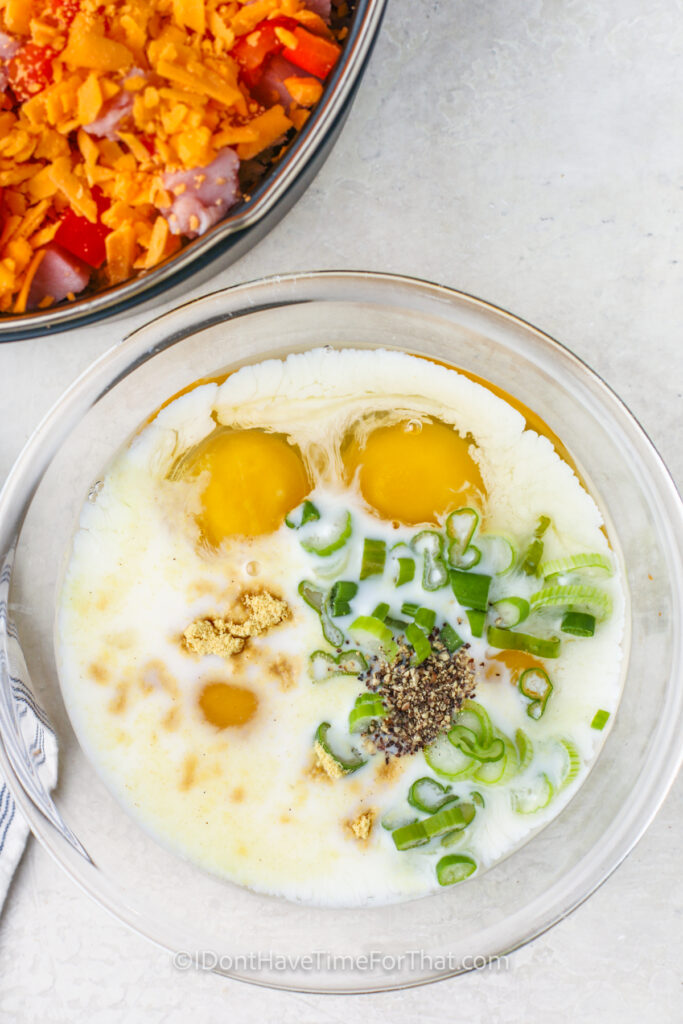 adding ingredients to eggs to make Instant Pot Breakfast Casserole