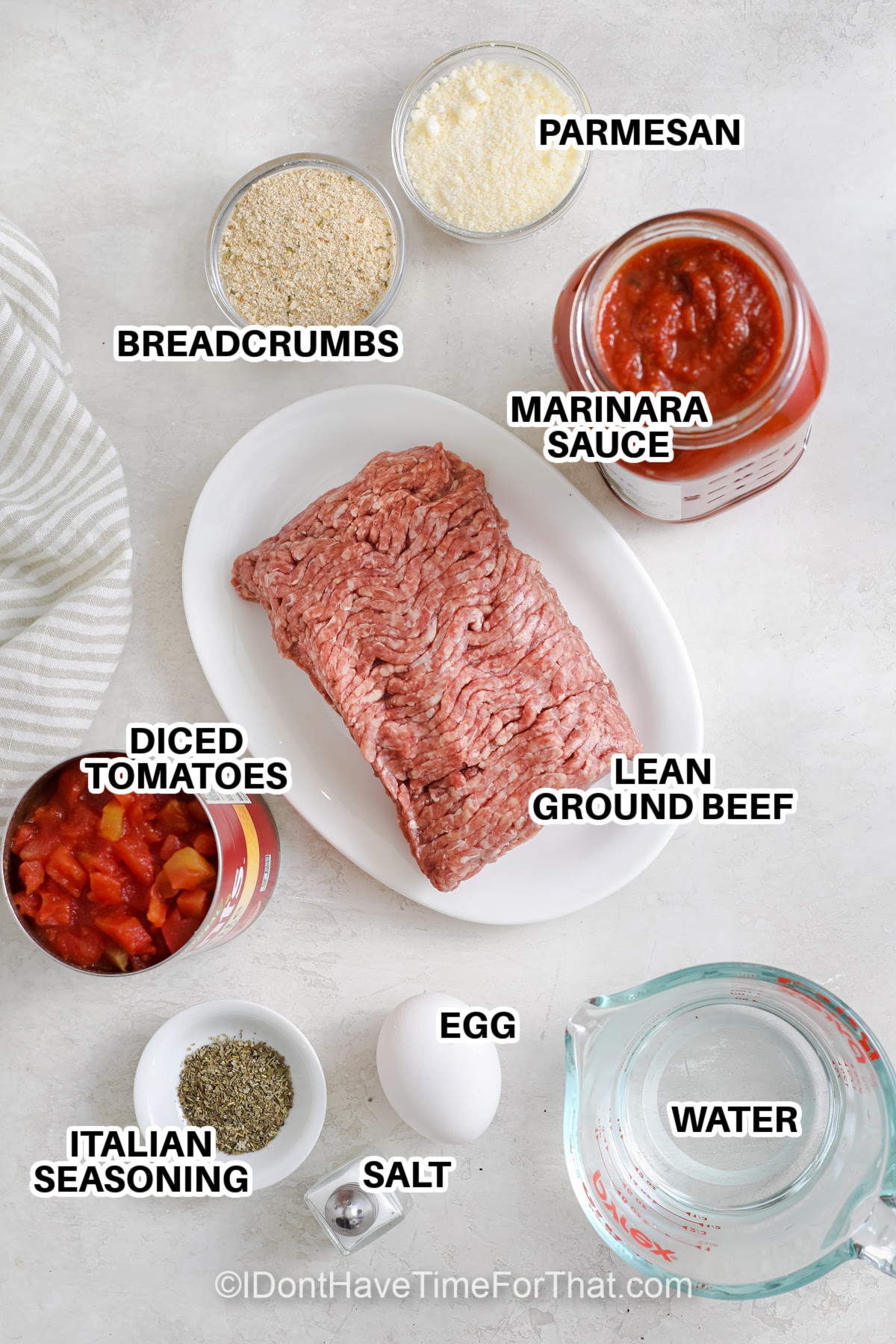 Ingredients to make Instant Pot Meatballs labeled: parmesan, breadcrumbs, marinara sauce, diced tomatoes, lean ground beef, egg, salt, water, and Italian Seasoning