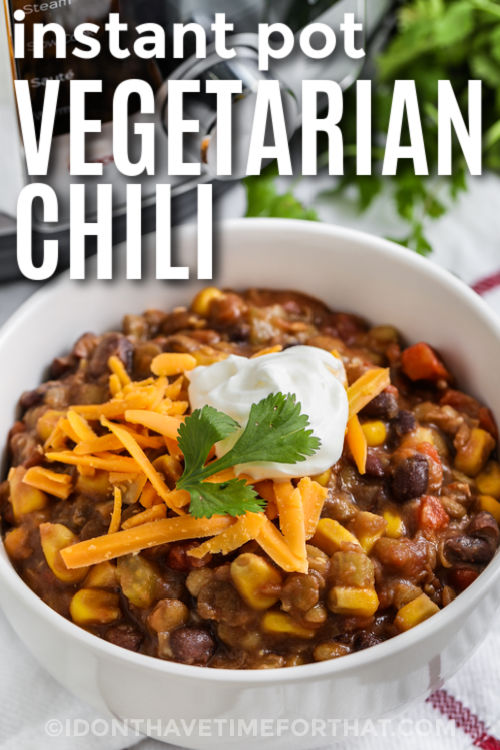Instant Pot Vegetarian Chili with sour cream and cheese on top with writing