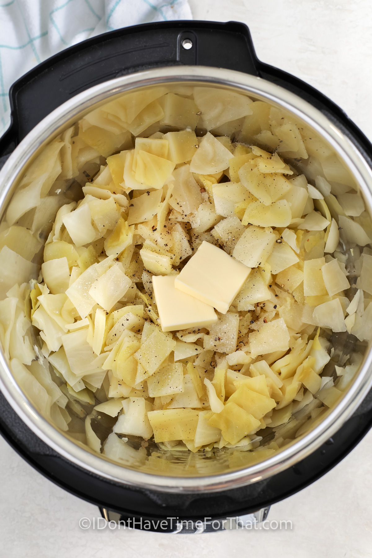 cooked cabbage in the instant pot with butter and seasoning on top